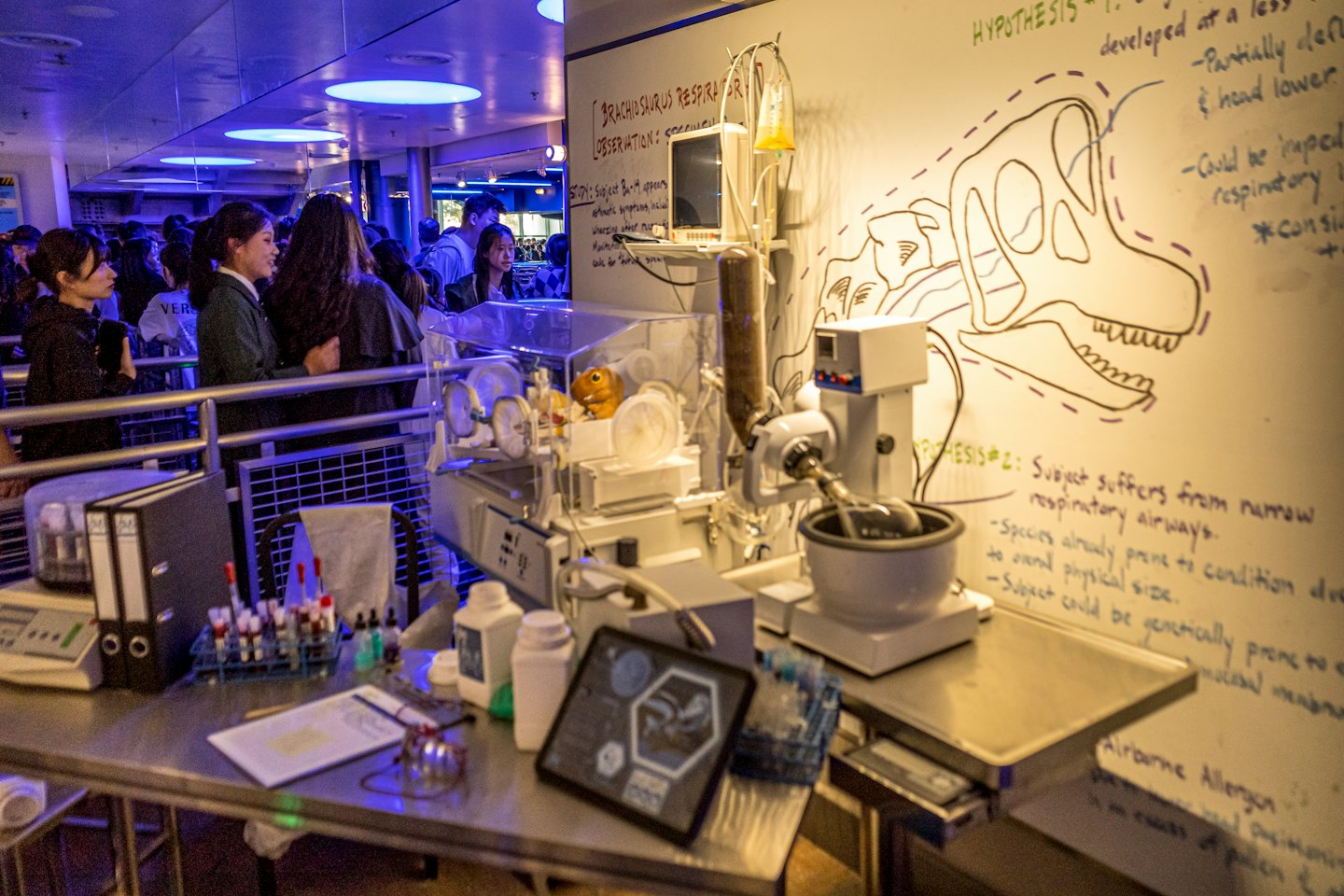 Scientific equipment and diagrams displayed on a table at a museum.
